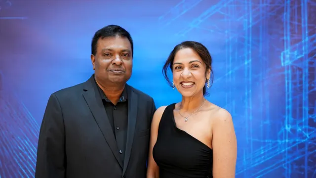 Two guests smiling at the media booth